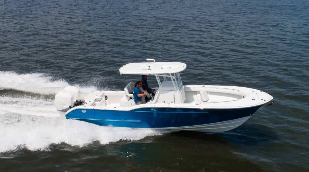 Blue and white center console boat speeding across calm blue water.