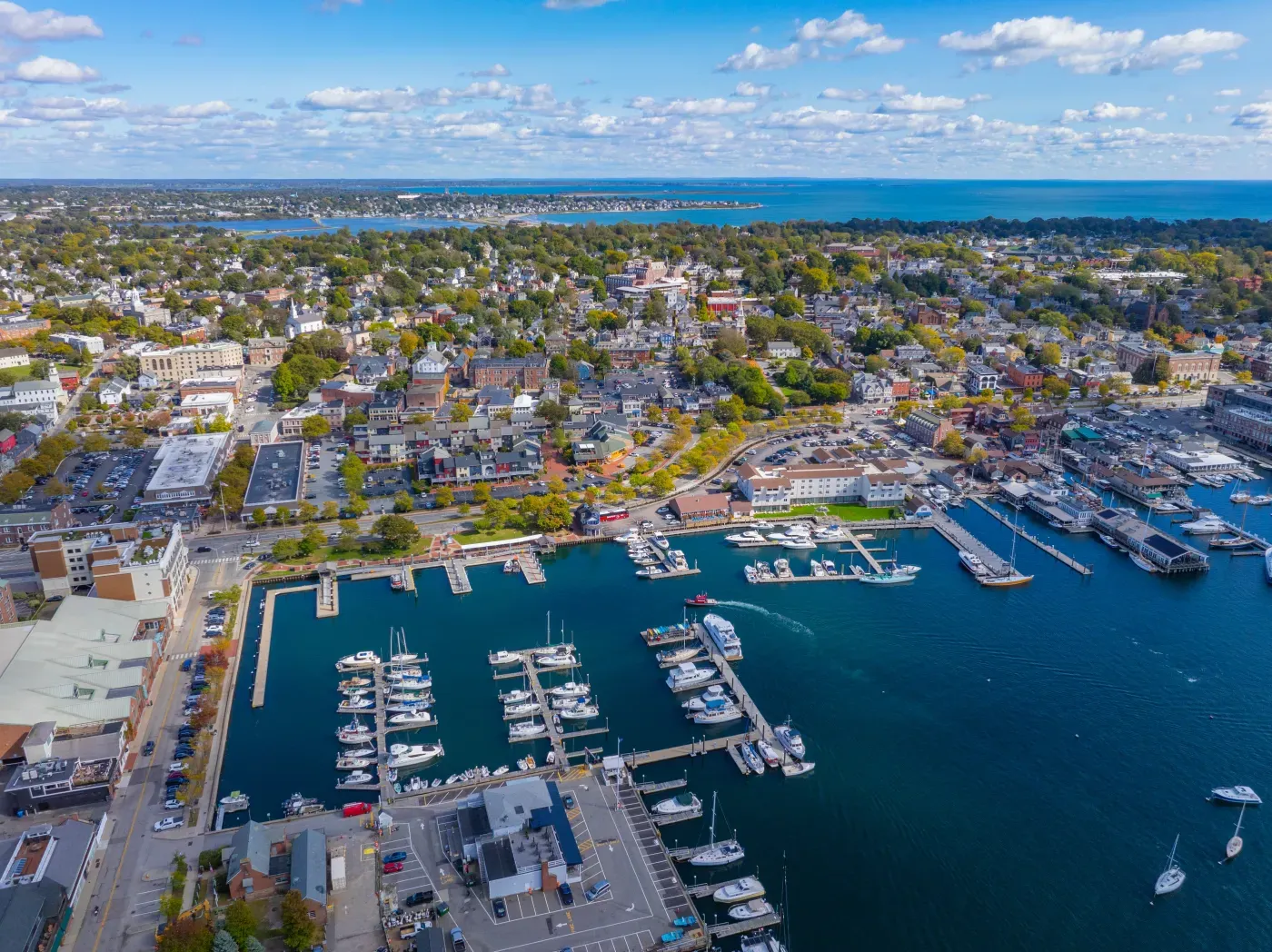Aerial view of a vibrant coastal town with a bustling marina and numerous boats.