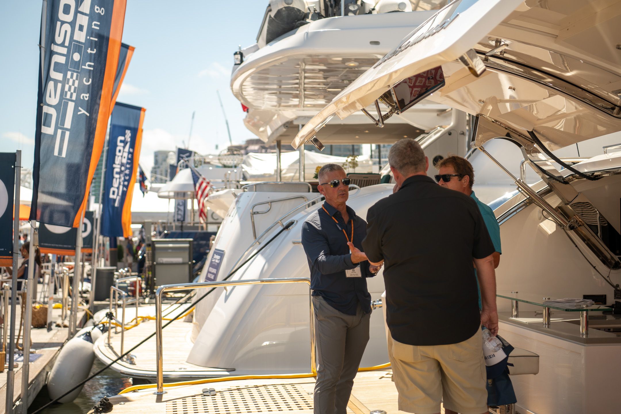 People converse on a luxurious yacht deck at a Denison Yachting event.