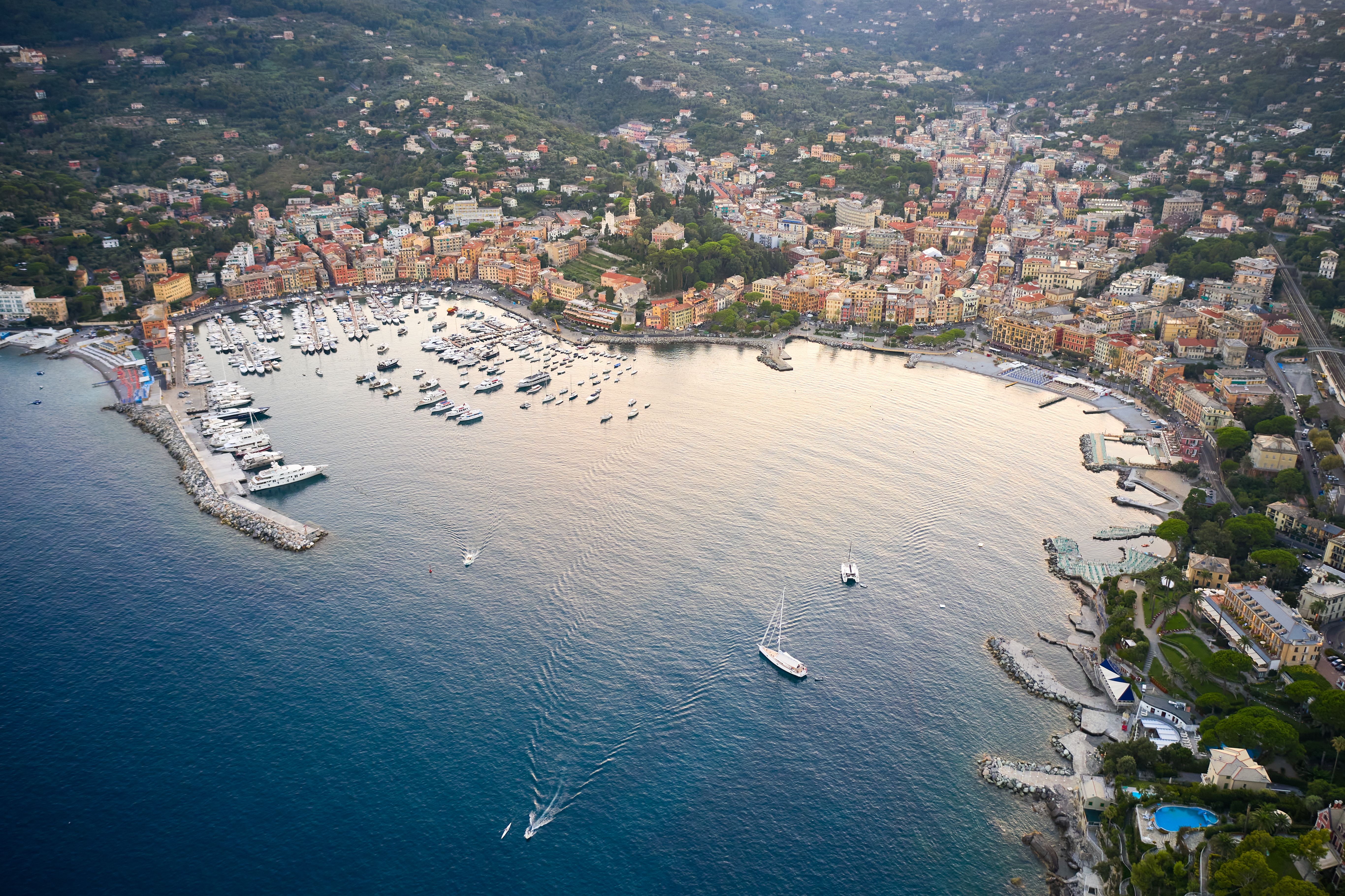 Aerial view of a picturesque coastal town with a bustling harbor full of boats.