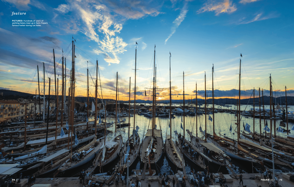 Many sailboats docked in a bustling harbor at sunset, with a beautiful colorful sky.