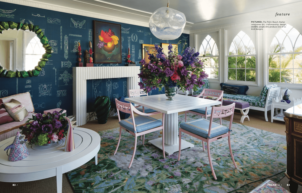 Vibrant dining room featuring a white table, pink chairs, blue walls, and abundant floral arrangements.