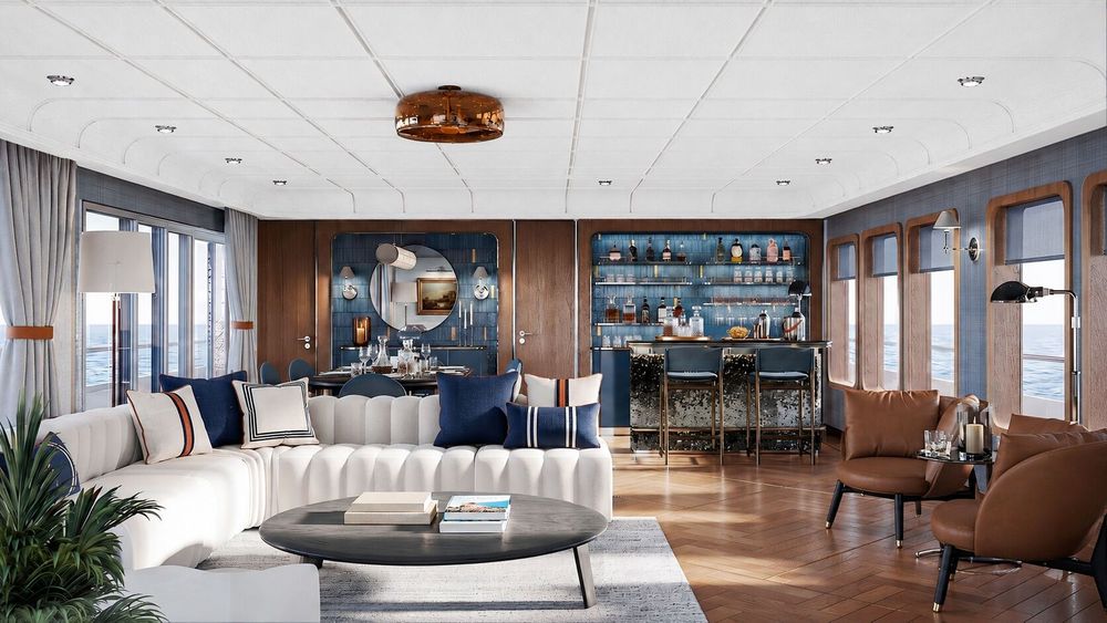 Luxurious lounge interior with a white sectional sofa, dining area, and bar, overlooking the sea.