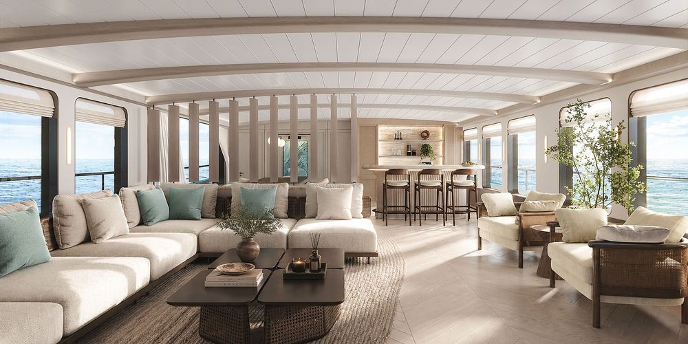 Luxurious lounge area with L-shaped sofa, bar, and ocean views from large windows.
