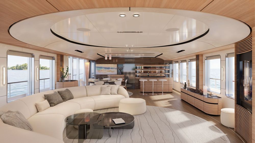 Spacious, modern yacht interior featuring a large white curved sofa and a stylish bar.