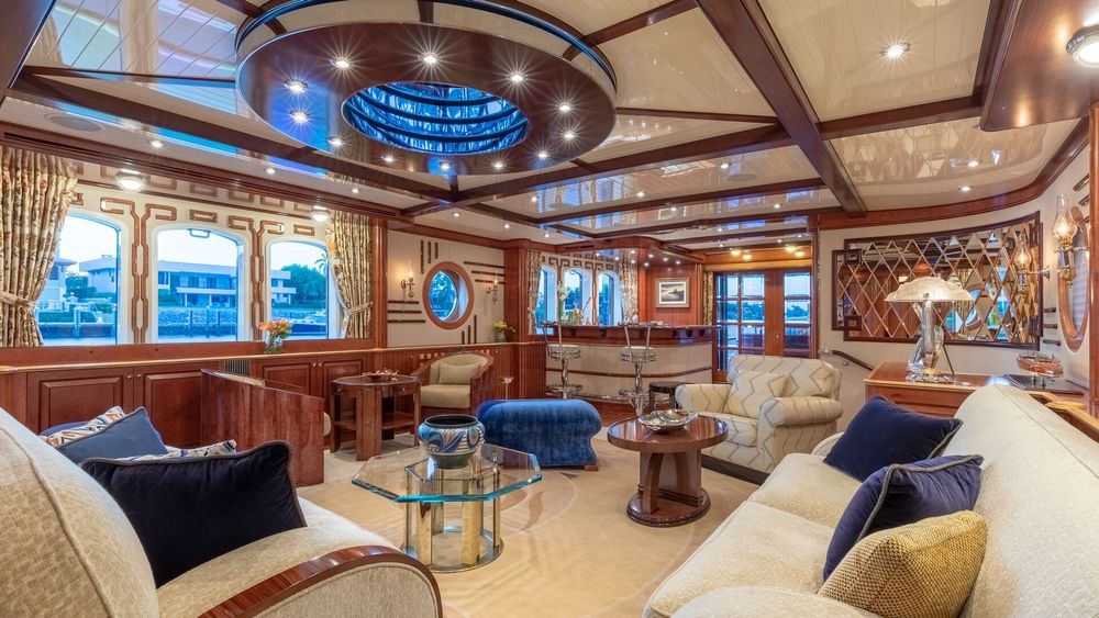 Elegant yacht living room with sofas, rich wood, and a circular ceiling skylight.