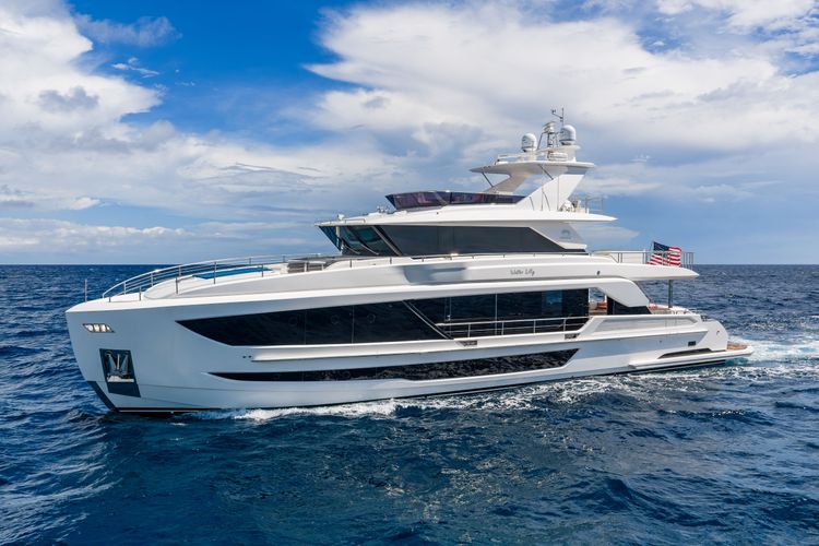 Large white luxury yacht with dark windows sailing on deep blue water.