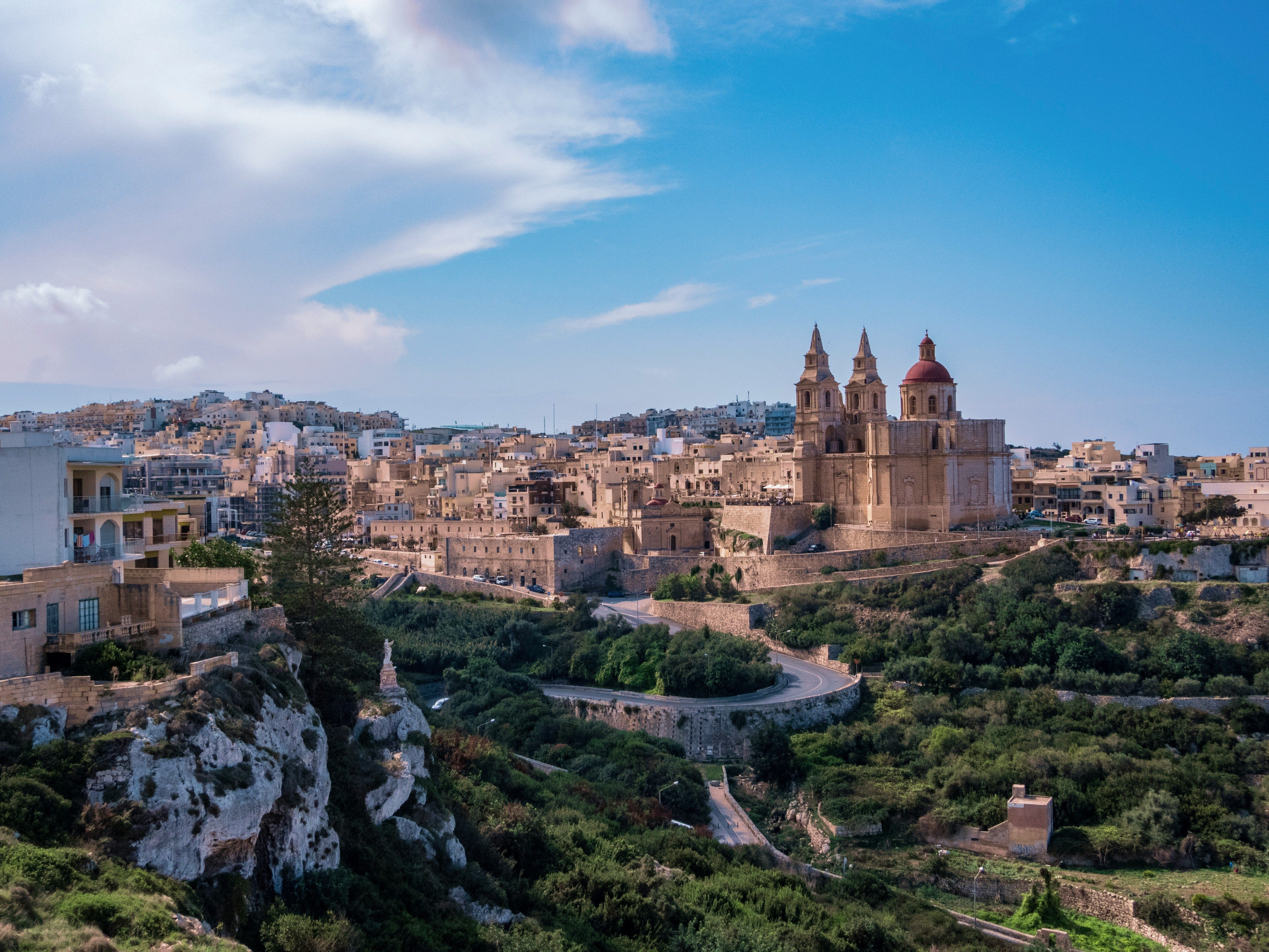 Elevated view of a historic Mediterranean town with a prominent cathedral dome and ancient buildings.